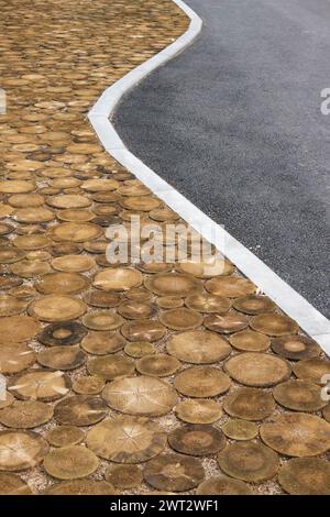 Mélange de divers matériaux sur la route de rue à l'extérieur. Disques en bois avec asphalte. Banque D'Images