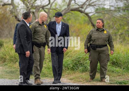 Brownsville (États-Unis d'Amérique). 29 février 2024. Le président américain Joe Biden, au centre, parle avec des agents de la patrouille frontalière américaine alors qu'il marche le long de la frontière américano-mexicaine dans la zone de la patrouille frontalière de Brownsville, le 29 février 2024 à Brownsville, Texas. Crédit : Adam Schultz/White House photo/Alamy Live News Banque D'Images