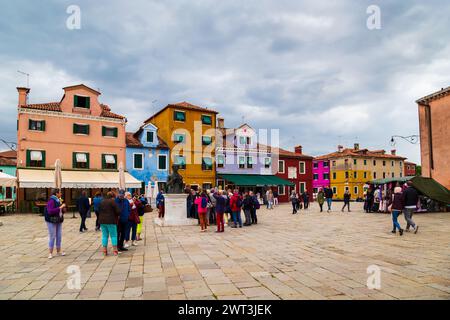 Burano, Italie - 6 octobre 2019 : touristes près de la statue de Baldassare Galuppi sur la place principale de Burano, la Piazza Galuppi. Bâtiments colorés traditionnels lumineux sur l'île de Burano, Venise, Italie. Banque D'Images