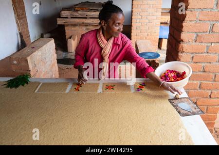 Femme main décorant des cartes de paer dans une usine de papier, Ambalavao, haute Matsiatra, Madagascar Banque D'Images