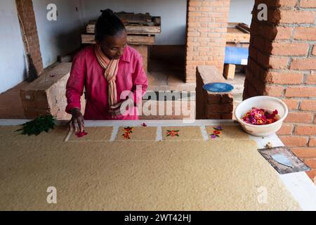 Femme main décorant des cartes de paer dans une usine de papier, Ambalavao, haute Matsiatra, Madagascar Banque D'Images