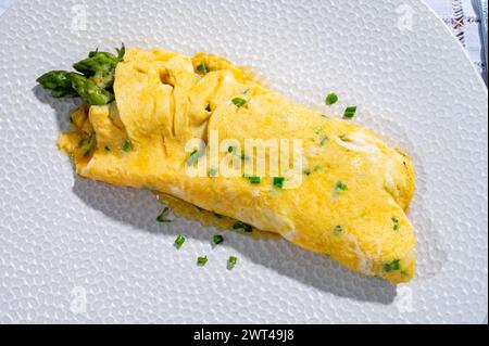 Omelette d'oeufs de poule farcie aux asperges vertes, savoureux plats végétariens, cuisine française, gros plan Banque D'Images