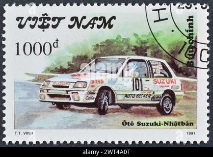 Timbre-poste oblitéré imprimé par le Vietnam, qui montre Suzuki - Japon, voitures de rallye vers 1991. Banque D'Images