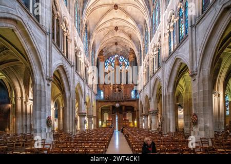 Ambiance tranquille à l'intérieur de l'église Saint-Séverin de Paris avec la lumière du soir filtrant à travers les vitraux. Banque D'Images