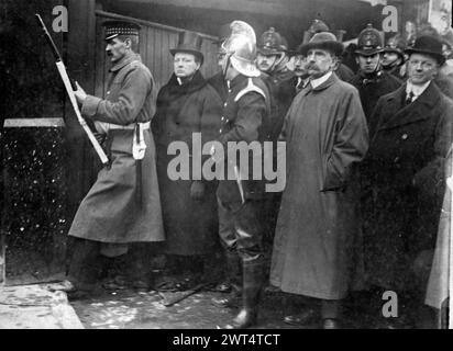 IL PARTICIPE AU SIÈGE DE SIDNEY STREET LE 1911 JANVIER. Winston Churchill, alors ministre de l'intérieur, regarde deuxième à partir de la gauche. Banque D'Images