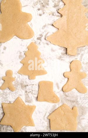 Biscuits de Noël crus dans différentes formes sur papier parchemin, plat Banque D'Images