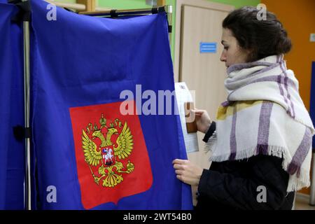 Saint-Pétersbourg, Russie. 15 mars 2024. Une femme vue entrer dans une cabine de vote dans un bureau de vote alors que le vote commence pour l'élection présidentielle russe de 2024. Quatre candidats participent aux élections : le leader du LDPR Slutsky, un membre du Parti communiste Kharitonov, l'actuel chef de l'Etat, Poutine auto-nommé et un membre du parti du Nouveau peuple Davankov. Crédit : SOPA images Limited/Alamy Live News Banque D'Images