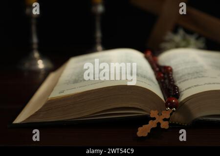 Croix en bois, perles de chapelet, la Bible et les bougies d'église sur la table, gros plan Banque D'Images