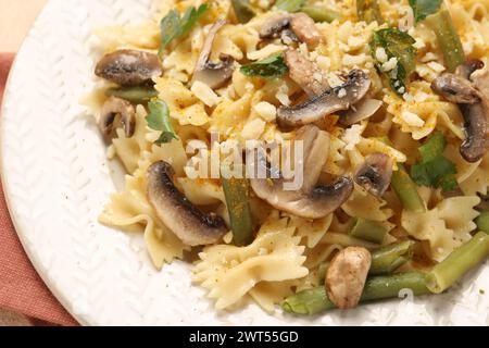 Pâtes végétariennes avec champignons, persil, haricots et fromage sur assiette blanche, gros plan Banque D'Images