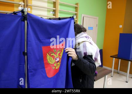 Saint-Pétersbourg, Russie. 15 mars 2024. Une femme vue entrer dans une cabine de vote dans un bureau de vote alors que le vote commence pour l'élection présidentielle russe de 2024. Quatre candidats participent aux élections : le leader du LDPR Slutsky, un membre du Parti communiste Kharitonov, l'actuel chef de l'Etat, Poutine auto-nommé et un membre du parti du Nouveau peuple Davankov. (Photo de Maksim Konstantinov/SOPA images/SIPA USA) crédit : SIPA USA/Alamy Live News Banque D'Images