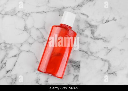 Bain de bouche frais en bouteille sur table en marbre blanc, vue de dessus Banque D'Images