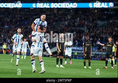 Mikel Merino de la Real Sociedad célèbre avec ses coéquipiers Mikel Oyarzabal de la Real Sociedad après avoir marqué le premier but de l'équipe lors du match LaLiga EA Sports entre la Real Sociedad et Cadix CF au stade Reale Arena le 15 mars 2024, à Saint-Sébastien, en Espagne. Crédit : Cesar Ortiz Gonzalez/Alamy Live News Banque D'Images