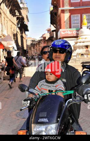 Famille sur une moto balade à travers une rue animée de la ville, la vallée de Katmandou. Katmandou, Népal Banque D'Images