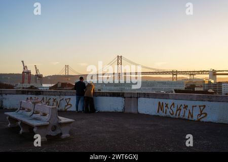 Deux personnes regardant le coucher du soleil au point de vue de Largo das Necessidades à Lisbonne, Portugal. 2 février 2024. Banque D'Images