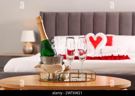 Lune de miel. Vin mousseux et verres sur la table en bois dans la chambre Banque D'Images