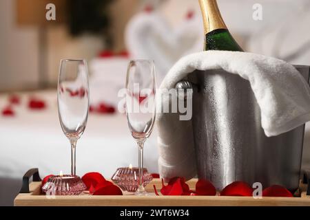 Lune de miel. Vin mousseux et verres sur la table en bois dans la chambre Banque D'Images