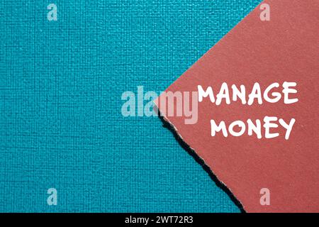Gérer les mots d'argent écrits sur un morceau de papier déchiré rouge avec fond bleu. Symbole commercial conceptuel. Copier l'espace. Banque D'Images