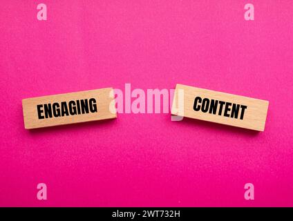 Mots de contenu engageants écrits sur des blocs de bois avec fond rose. Symbole conceptuel. Copier l'espace. Banque D'Images