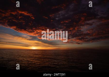 Lever de soleil sur la mer et spectaculaires nuages rouges ardents à Costa del Azahar à Peniscola en Espagne Banque D'Images