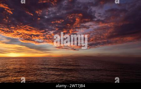 Lever de soleil sur la mer et spectaculaires nuages rouges ardents à Costa del Azahar à Peniscola en Espagne Banque D'Images