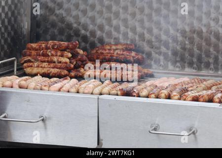 Erfurt, Allemagne. 16 mars 2024. Les bratwursts sont disposés sur un grill au charbon de bois à l'ouverture de la session de bratwurst avec le festival 'Rostkultur' sur la place de la cathédrale. Un total de onze types différents de saucisses grillées peuvent être échantillonnés sur les stands. Crédit : Bodo Schackow/dpa/Alamy Live News Banque D'Images