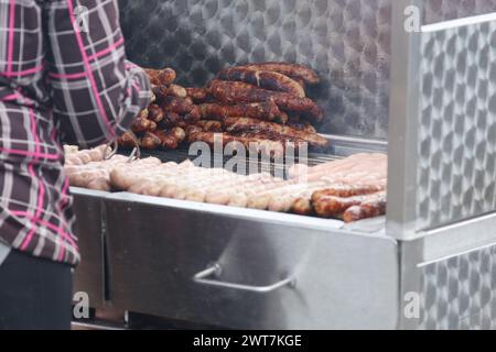 Erfurt, Allemagne. 16 mars 2024. Les bratwursts sont rôtis sur un grill au charbon de bois à l'ouverture de la session de bratwurst avec le festival 'Rostkultur' sur la place de la cathédrale. Un total de onze types différents de saucisses grillées peuvent être échantillonnés sur les stands. Crédit : Bodo Schackow/dpa/Alamy Live News Banque D'Images