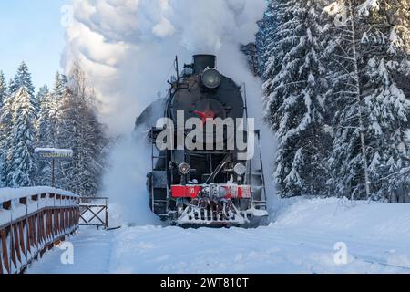 Ruskeala, RUSSIE - 20 JANVIER 2024 : le train rétro 'Ruskeala Express' avec locomotive à vapeur l-5164 arrive à la station Ruskeala Mountain Park Banque D'Images
