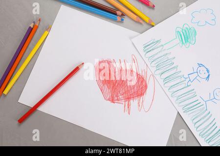 Dessins d'enfants mignons et crayons colorés sur table grise, pose à plat Banque D'Images