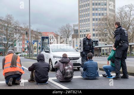 16.03.24 : eine Frau sitzt am Kšlner Ebertplatz auf der Strasse mit einer Grafik der Temperaturentwicklung der letzten Jahre um den Hals. Heute startet Banque D'Images