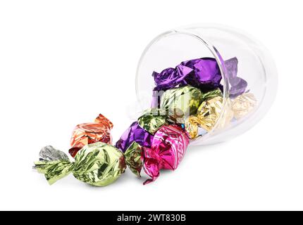 Tasse en verre avec des bonbons dans des emballages colorés isolés sur blanc Banque D'Images