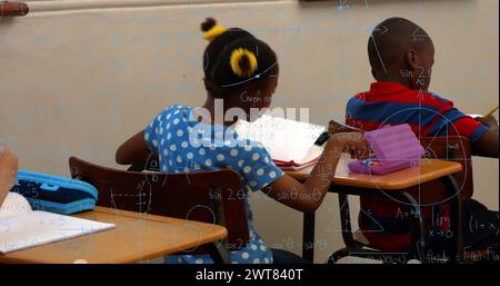 Image de formules mathématiques sur des enfants afro-américains apprenant à l'école Banque D'Images