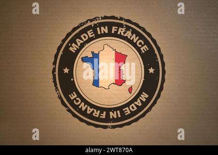 Papier brun avec en son milieu un timbre de style rétro fabriqué en France incluant la carte et le drapeau de la France. Banque D'Images