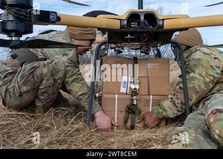 Fort Drum, États-Unis. 05 mars 2024. Les soldats de la 10e division de montagne de l'armée américaine sécurisent un paquet de repas, prêts à manger à un TRV 150, véhicule de ravitaillement tactique, pendant l'entraînement à Fort Drum, le 5 mars 2024, à Fort Drum, New York. Les nouveaux drones d'alimentation électrique peuvent fournir jusqu'à 440 livres de charge utile sur le champ de bataille. Crédit : SFC Neysa Canfield/US Army/Alamy Live News Banque D'Images