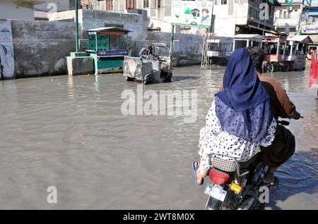 Route inondée par le débordement des eaux usées, créant des problèmes pour les résidents et les navetteurs, montrant la négligence des autorités concernées, à Hali Road à Hyderabad le samedi 16 mars 2024. Banque D'Images