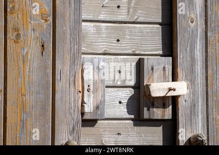 Un mur de planches de bois avec une poignée en bois pour fermer la porte Banque D'Images