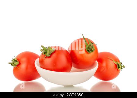 Plusieurs tomates cerises mûres avec plaque en céramique blanche, macro, isolées sur fond blanc. Banque D'Images