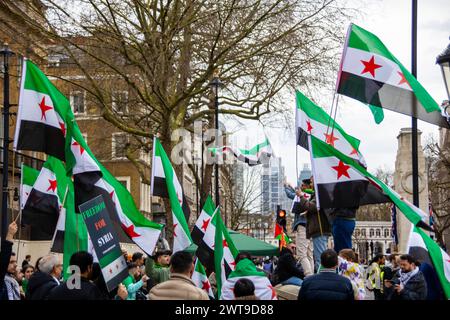 La campagne de solidarité syrienne a célébré l'anniversaire de la Révolution syrienne avec un événement commémoratif à Whitehall. Le rassemblement, retentissant avec la déclaration "nous préférerions périr que d'être gouvernés par Assad!", a souligné la quête persistante de démocratie et de droits de l'homme en Syrie, jetant un coup de projecteur sur le conflit prolongé et l'esprit indomptable de ceux qui militent pour le changement. Crédit : Sinai Noor/Alamy Live News Banque D'Images