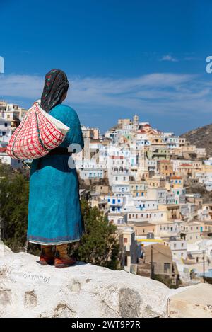 Statue d'une femme grecque dans une tenue traditionnelle donnant sur Olympos, Karpathos, Grèce. Banque D'Images
