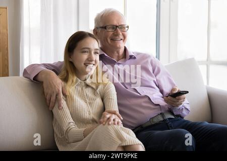 Pré-adolescente et grand-père passent du temps ensemble à regarder un film Banque D'Images