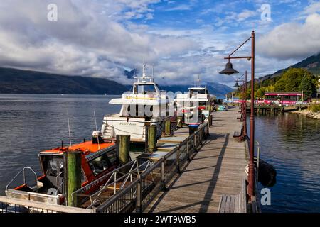 Queenstown, Nouvelle-Zélande - 24 décembre 2022 : la ville principale de Queenstown avec des navires amarrés de services d'aventure et d'expérience sur le lac Wakatipu. Banque D'Images