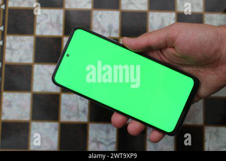 Téléphone portable masculin avec écran vert Banque D'Images