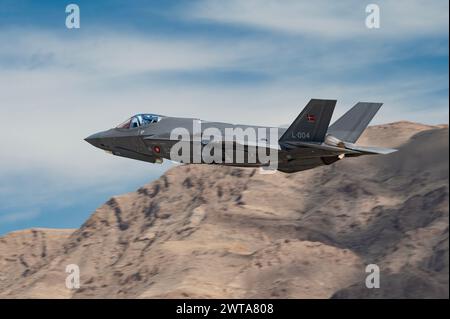 Un F-35A de la Royal Danish Air Force de la base aérienne de Luke (AFB), Arizona, décolle pour la mission Red Flag-Nellis 24-2 à Nellis AFB, Nevada, le 13 mars 2024. L'intégration d'actifs de cinquième génération, tels que le F-35, est une étape vitale vers l'amélioration de notre sécurité collective. Ces avions évolués offrent des capacités sans précédent, y compris une furtivité améliorée, la fusion de capteurs et la connectivité réseau, ce qui nous permet de maintenir notre supériorité aérienne et de dissuader les adversaires potentiels. (Photo de l'US Air Force par William R. Lewis) RFNAFB ; DoD ; ACC ; Air combat Command ; DoD; mise au point automatique prête ; létalité ; prêt ; Banque D'Images