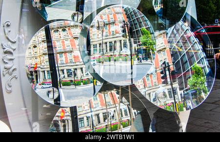 Reflets des bâtiments de Piccadilly Street dans l'affichage en vitrine de multiples miroirs concaves - Londres, Royaume-Uni Banque D'Images