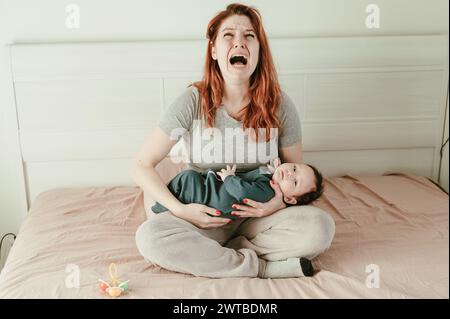 Une femme tient un enfant dans ses bras et pleure. Dépression du post-partum. Banque D'Images