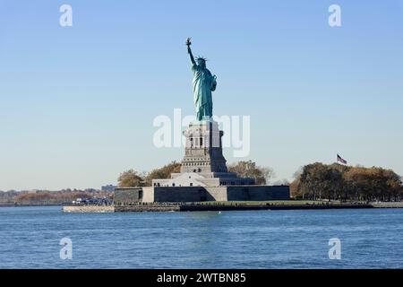 La Statue de la liberté sur une île par une journée ensoleillée entourée d'eau bleue claire, Manhattan, Down Town, New York City, New York, États-Unis, Amérique du Nord Banque D'Images