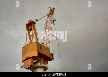 Une grue jaune dans le port de Vigo par temps nuageux Banque D'Images