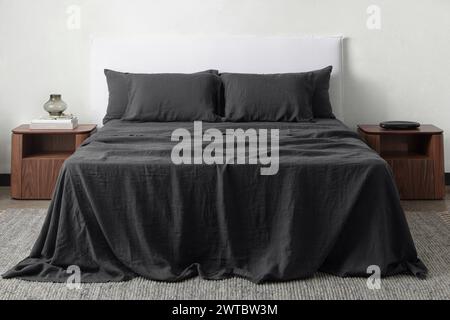 lit confortable avec oreillers dans une chambre contemporaine. maquette de mur design intérieur. chambre blanche avec tapis et mur blanc au-dessus de la vue bed.front. Banque D'Images