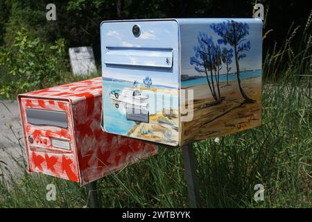 Gros plan de boîtes aux lettres colorées, amusantes et différentes peintes dans la campagne en France Banque D'Images