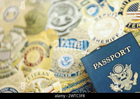 KIEV, UKRAINE - 9 MARS 2024 le passeport américain se trouve sur les badges de différents services de police des États-Unis imprimés sur papier gros plan Banque D'Images