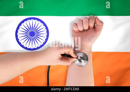 La tête d'un stéthoscope médical au poignet (gros plan) sur fond de drapeau indien. Concept de système de santé indien Banque D'Images